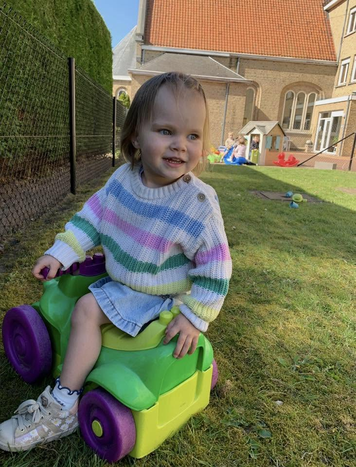 Peuter op een loopauto in de tuin